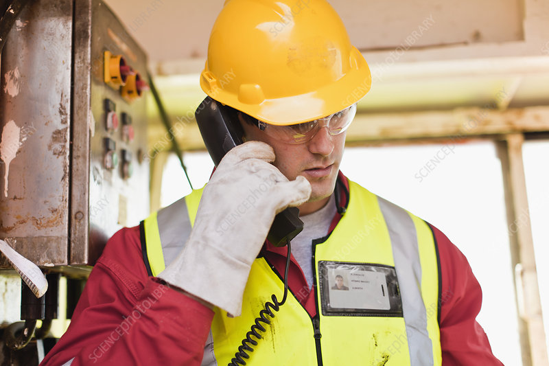 Worker talking on phone on oil rig